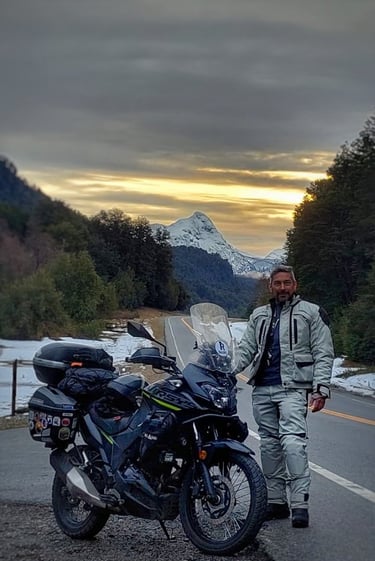 a man standing next to a motorcycle on a road